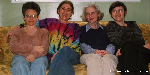 Four women sit on a sofa