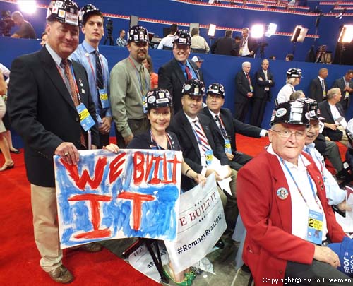 Delegates wear black hardhats with stickers